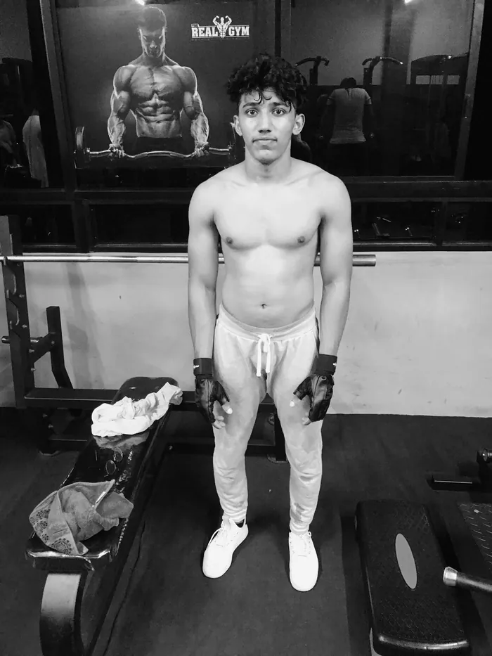 Client one before the program — slim build, standing in the gym